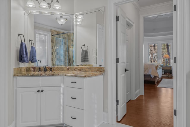 bathroom with ornamental molding, hardwood / wood-style floors, vanity, and walk in shower