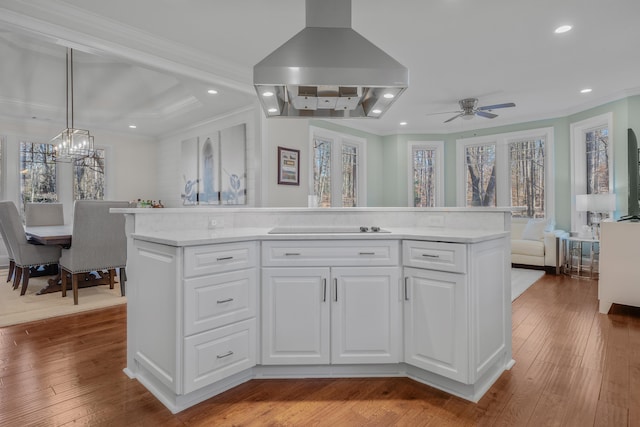 kitchen with white cabinetry, island exhaust hood, a kitchen island, and pendant lighting