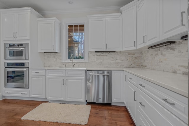 kitchen with white cabinetry, sink, crown molding, and stainless steel appliances