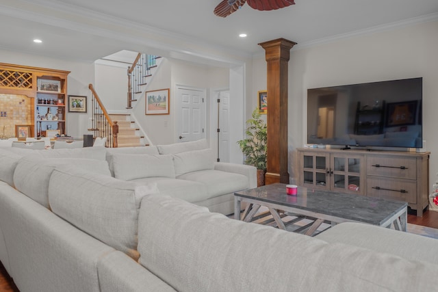 living room featuring decorative columns, ornamental molding, wood-type flooring, and ceiling fan