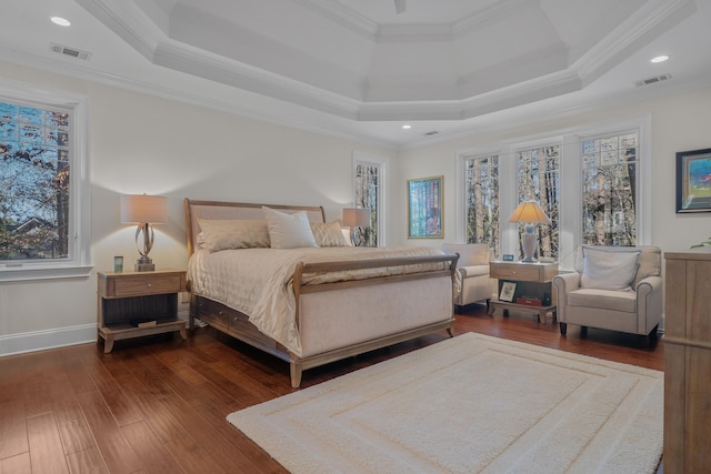 bedroom with a raised ceiling, ornamental molding, and dark hardwood / wood-style flooring