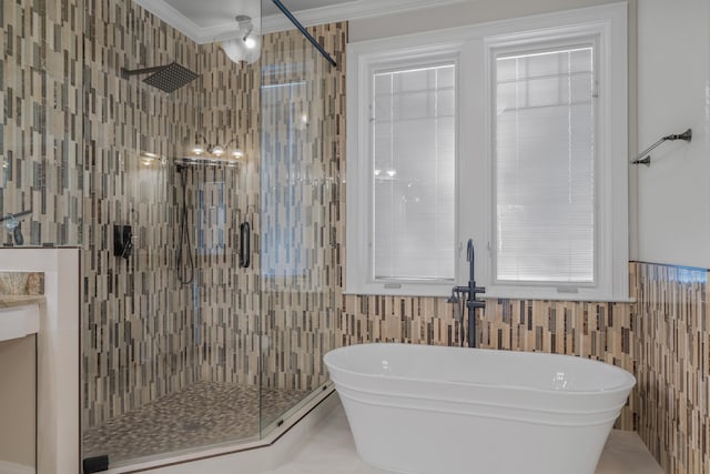 bathroom featuring tile walls, sink, ornamental molding, and plus walk in shower