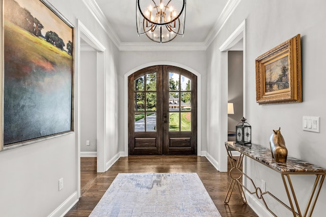 entrance foyer featuring crown molding, a notable chandelier, dark hardwood / wood-style flooring, and french doors