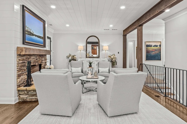 living room featuring ornamental molding, a fireplace, hardwood / wood-style floors, and wooden ceiling