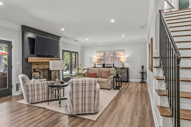 living room featuring ornamental molding, a brick fireplace, and light hardwood / wood-style flooring