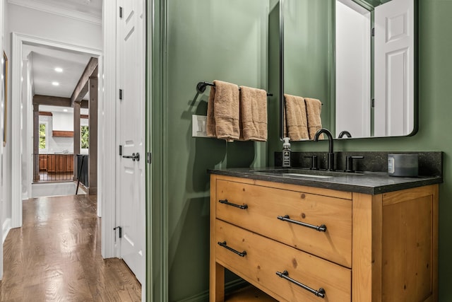 bathroom with vanity, hardwood / wood-style floors, and crown molding