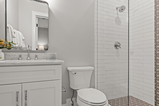 bathroom featuring tiled shower, vanity, and toilet