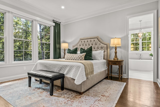 bedroom featuring dark hardwood / wood-style flooring, connected bathroom, and crown molding