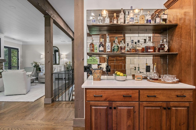 bar with crown molding and wood-type flooring