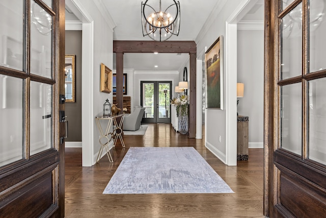 foyer featuring crown molding, dark hardwood / wood-style floors, a chandelier, and french doors