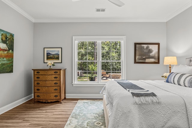 bedroom with light hardwood / wood-style flooring, ornamental molding, and ceiling fan