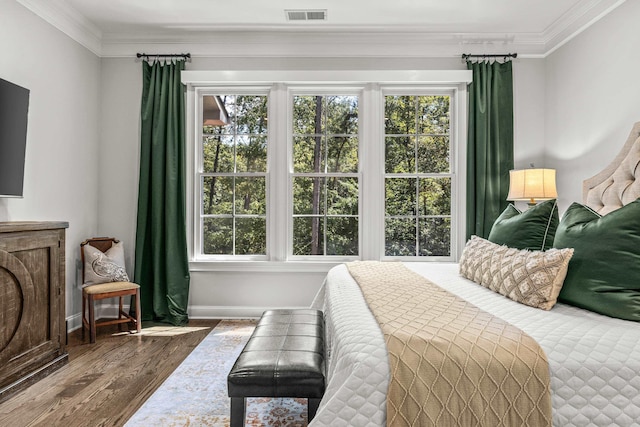 bedroom with multiple windows, dark wood-type flooring, and ornamental molding