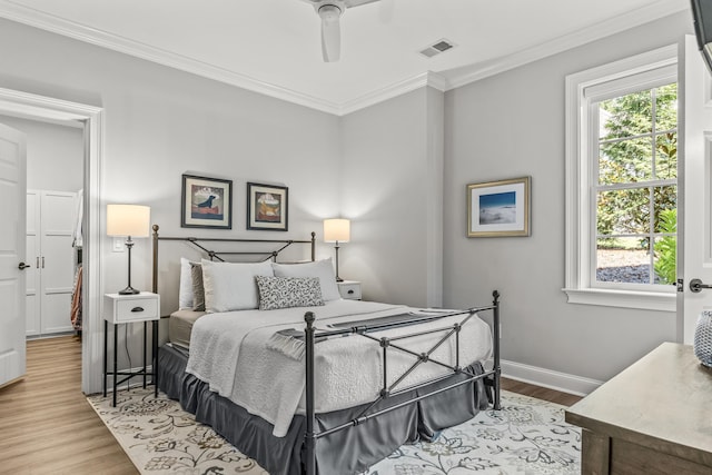 bedroom with multiple windows, ornamental molding, light hardwood / wood-style floors, and ceiling fan