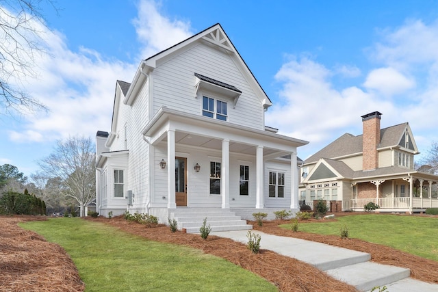 view of front of home with covered porch and a front lawn