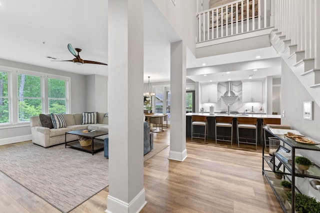 1010F Tailwater, Greensboro, GA 30642 - living room with baseboards, light wood-style flooring, ceiling fan with notable chandelier, and visible vents