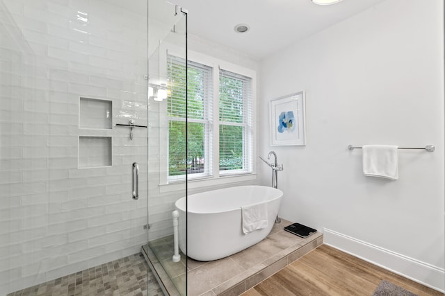 1010F Tailwater, Greensboro, GA 30642 - bathroom featuring wood finished floors, baseboards, a soaking tub, and a stall shower