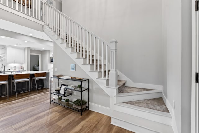 1010F Tailwater, Greensboro, GA 30642 - stairs featuring baseboards, a towering ceiling, and wood finished floors