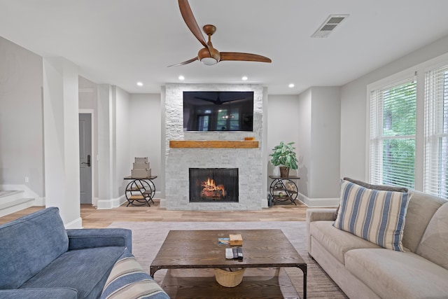 1010F Tailwater, Greensboro, GA 30642 - living room with a ceiling fan, a stone fireplace, visible vents, wood finished floors, and baseboards