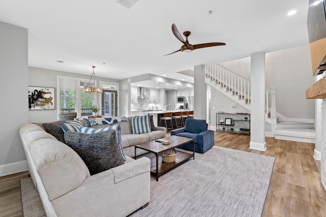 1010F Tailwater, Greensboro, GA 30642 - living room with stairs, baseboards, ceiling fan with notable chandelier, and light wood-style floors