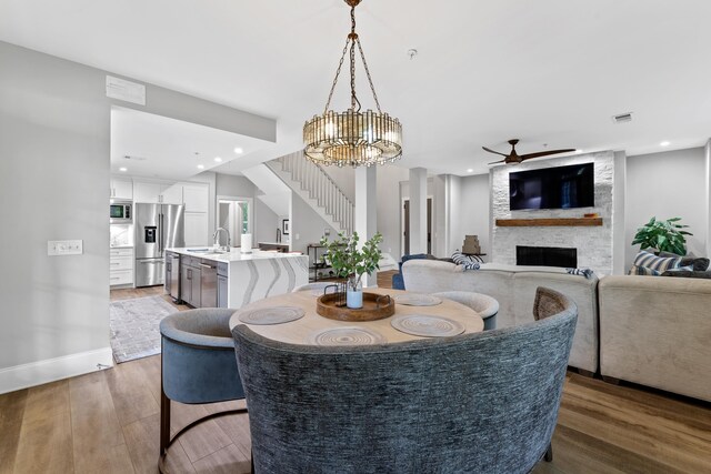 1010F Tailwater, Greensboro, GA 30642 - dining space featuring visible vents, wood finished floors, ceiling fan with notable chandelier, and a fireplace