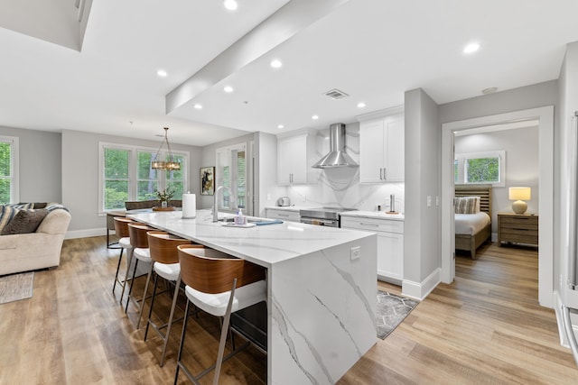 1010F Tailwater, Greensboro, GA 30642 - kitchen featuring wall chimney range hood, visible vents, a wealth of natural light, and a sink