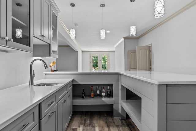 kitchen with pendant lighting, sink, gray cabinets, and ornamental molding