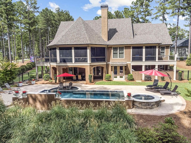 rear view of house featuring a fire pit, french doors, a fenced in pool, a sunroom, and a patio area