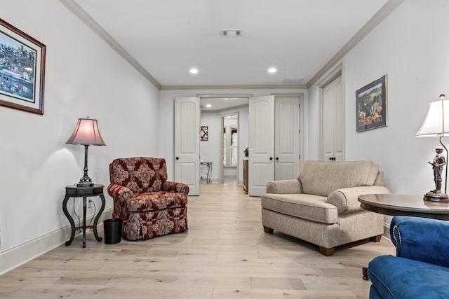 living room with ornamental molding and light hardwood / wood-style floors