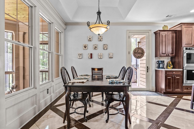 dining space with a raised ceiling