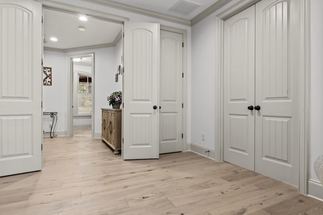 hallway with ornamental molding and light wood-type flooring