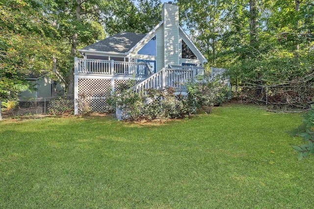 rear view of house featuring a yard and a deck