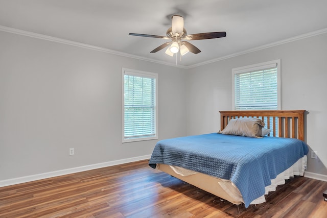 bedroom with crown molding, dark wood-type flooring, and ceiling fan