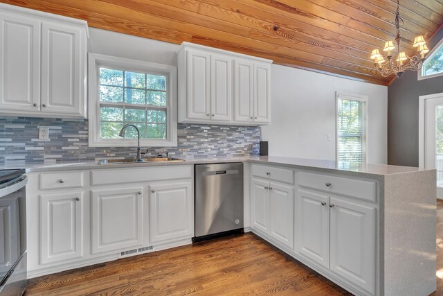 kitchen with pendant lighting, sink, white cabinets, stainless steel dishwasher, and kitchen peninsula