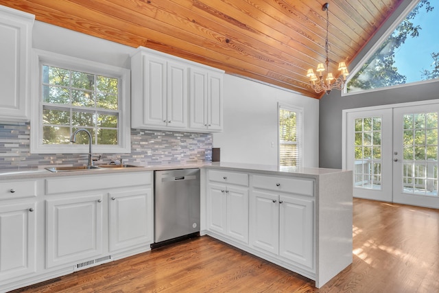 kitchen with sink, dishwasher, white cabinetry, hanging light fixtures, and kitchen peninsula