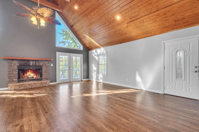 unfurnished living room with high vaulted ceiling, a fireplace, hardwood / wood-style flooring, wood ceiling, and french doors