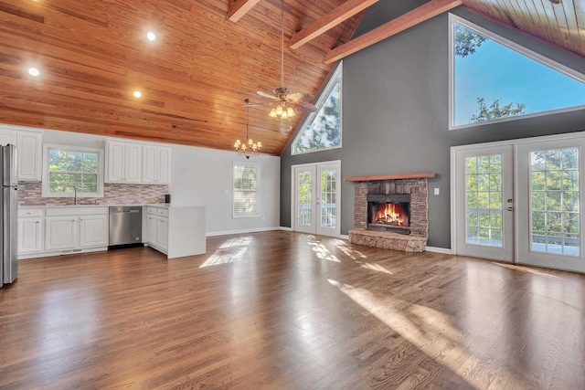 unfurnished living room featuring hardwood / wood-style flooring, a stone fireplace, wooden ceiling, and french doors