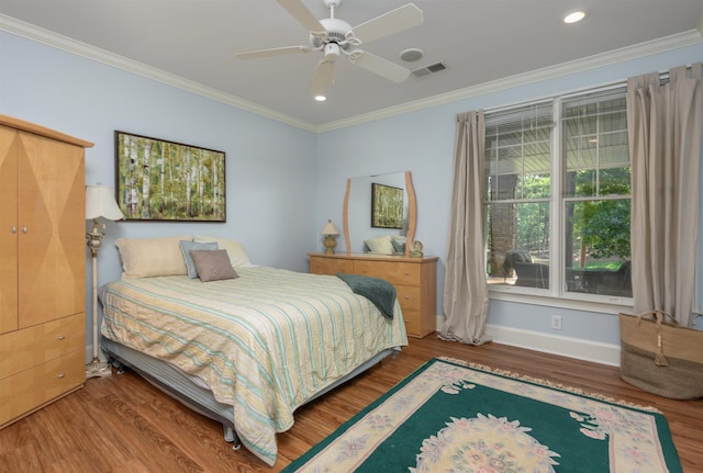 bedroom featuring hardwood / wood-style flooring, ornamental molding, and ceiling fan