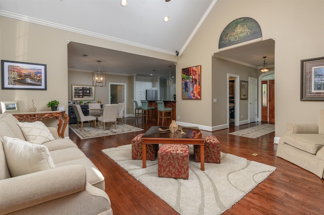 living room featuring a notable chandelier, crown molding, dark wood-type flooring, and high vaulted ceiling