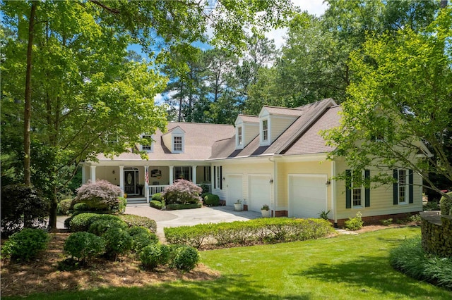 cape cod house featuring a garage, a front lawn, and a porch