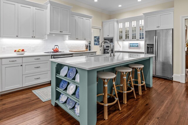 kitchen with an island with sink, recessed lighting, appliances with stainless steel finishes, light countertops, and a sink