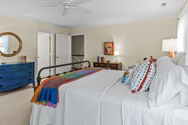 carpeted bedroom with crown molding, multiple windows, a ceiling fan, and visible vents