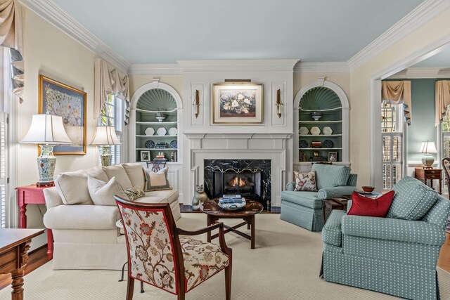 living area with built in features, carpet floors, crown molding, and a premium fireplace