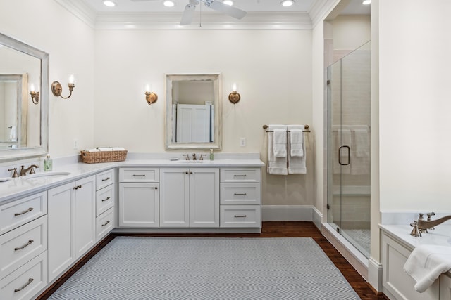 full bathroom featuring crown molding, ceiling fan, a shower stall, and wood finished floors