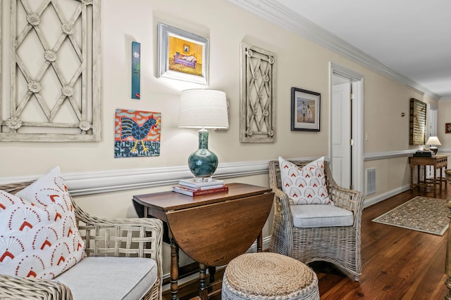 sitting room featuring visible vents, ornamental molding, and wood finished floors