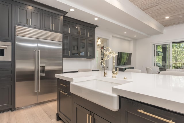 1100 Neary Rdg, Greensboro, GA 30642 - kitchen with light countertops, a sink, stainless steel built in fridge, light wood-style flooring, and glass insert cabinets