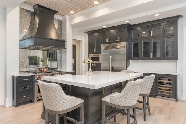1100 Neary Rdg, Greensboro, GA 30642 - kitchen with high end appliances, light wood-style floors, light countertops, premium range hood, and recessed lighting
