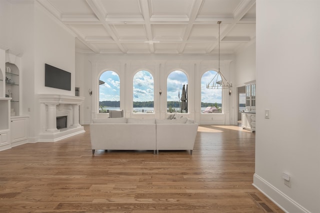 1191 Cory Cir, Greensboro, GA 30642 - living area with wood finished floors, a fireplace with raised hearth, a chandelier, coffered ceiling, and beamed ceiling