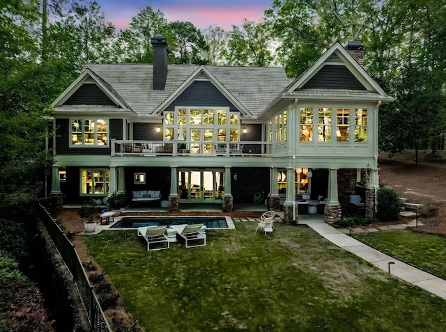 1081 Terrell Cir, Greensboro, GA 30642 - back of property at dusk featuring a chimney, outdoor lounge area, a lawn, an outdoor pool, and french doors