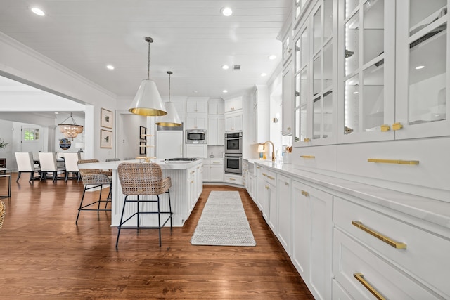 1081 Terrell Cir, Greensboro, GA 30642 - kitchen with appliances with stainless steel finishes, white cabinets, a breakfast bar area, ornamental molding, and a kitchen island