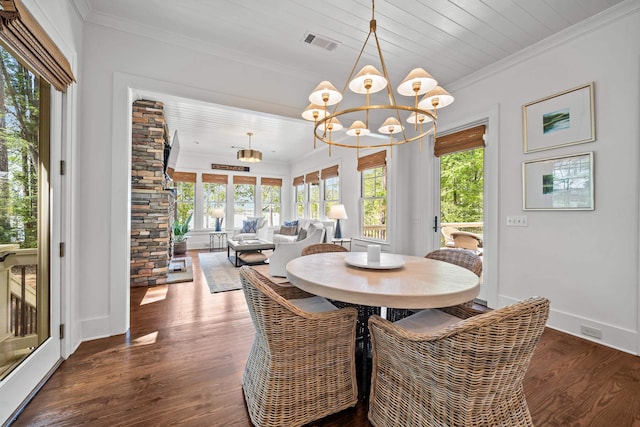 1081 Terrell Cir, Greensboro, GA 30642 - dining space featuring crown molding, a chandelier, wood finished floors, and healthy amount of natural light